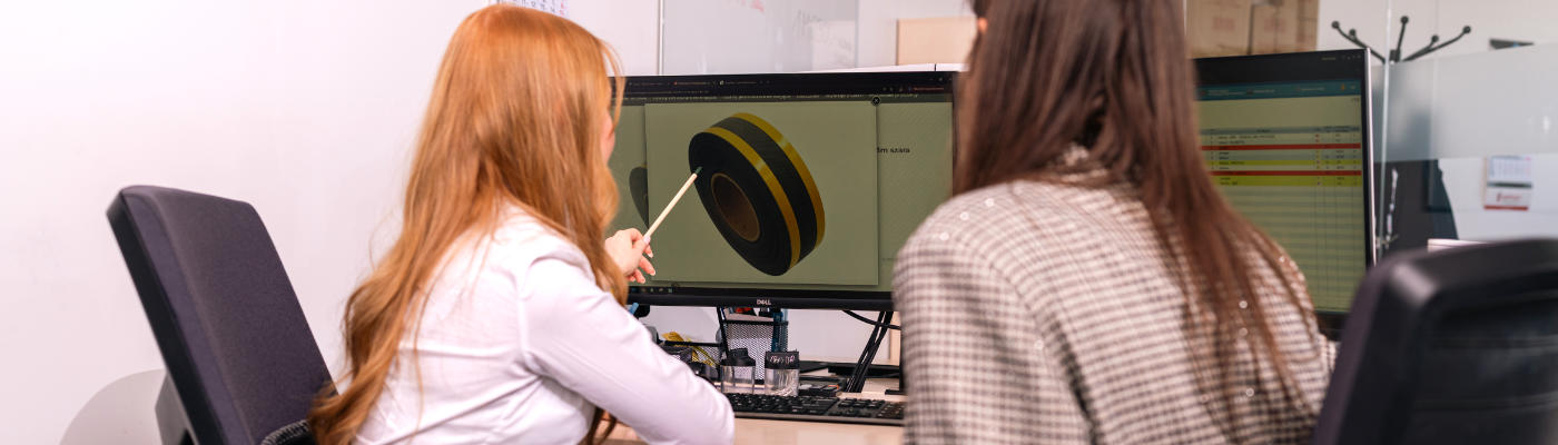 Kobiety w biurze wskazujące na monitorze na taśmę